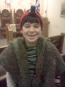 Max is wearing Tefillin (phylacteries) and a self-made Tallit (prayer shawl) for morning services.